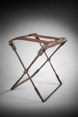 a small wooden tray with a leather handle on a stand