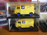 deux camions jouets jaunes dans une vitrine posée sur une table