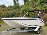 a boat that is parked on a trailer in the grass