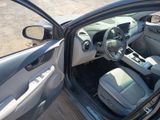 the interior of a car with the door open and the driver ' s seat down