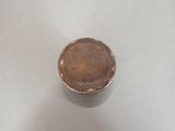a metal container with a brown lid sitting on a table