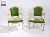 paire de fauteuils en velours vert avec des accoudoirs en bois sculpté