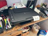 a printer sitting on top of a wooden desk next to other office supplies