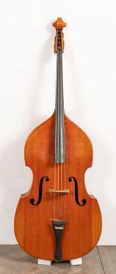 a close up of a cello on a stand on a wooden floor