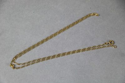a close up of a gold chain on a white surface