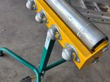 an image of a roller conveyor with a roll of metal on it