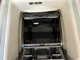 a white refrigerator with a black tray inside of it