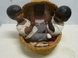 une figurine représentant trois enfants dans un panier posé sur une table