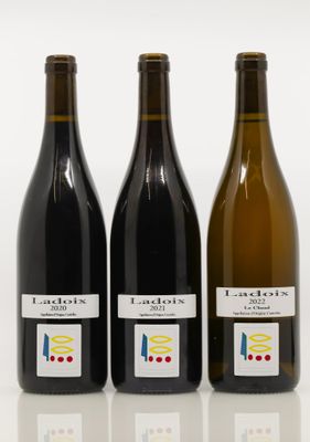 three bottles of wine sitting next to each other on a white surface