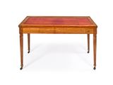 a small wooden table with red leather top on casteors