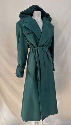 Le manteau est vert et possède une capuche.