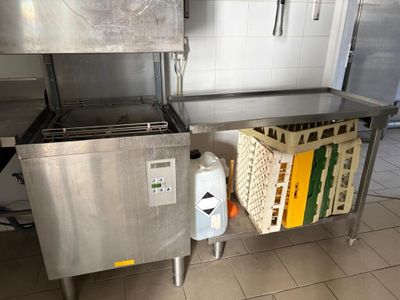a kitchen with a stainless steel counter and a metal trash can