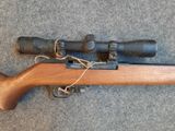 a rifle with a scope and a rifle scope on the ground