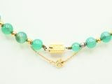 a green beaded necklace with a gold plated clasp