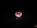 un diamant rose sur une surface noire