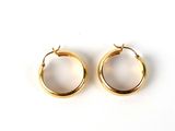 two pairs of gold hoop earrings on a white surface