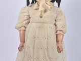 an image of a doll with a hat and dress on a white surface
