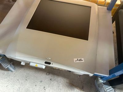 a laptop computer sitting on a cart on the floor