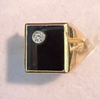 yellow gold ring with a black stone and a white diamond