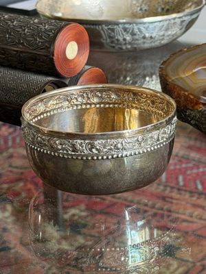 a silver bowl sitting on top of a glass table