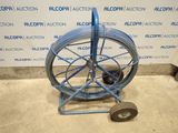 an image of a blue hose cart with wheels on the floor