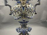un vase bleu et blanc sur lequel est représenté un visage