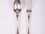 two spoons and a fork on a white surface