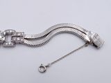 silver bracelet with a clasp and a chain with a clasp on a white background