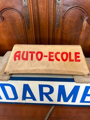 a sign on a bed with a wooden headboard in the background