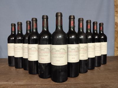 six bottles of red wine lined up on a wooden table