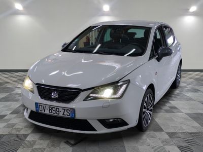 la voiture blanche est garée sur un sol en damier dans le garage