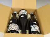three bottles of wine in a box on a table
