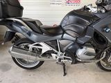 a black motorcycle parked in a garage with luggage on the back of it
