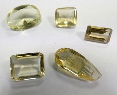 three yellow topazte and two green topazte faceted gems
