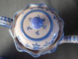 a blue and white teapot sitting on a table