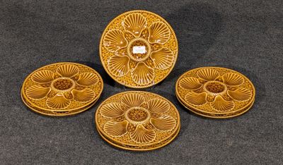 quatre pièces de poterie jaune posées sur une table