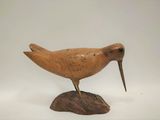 un petit oiseau en bois perché sur un rocher