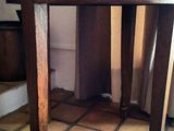 une petite table en bois avec un plateau en marbre, posée sur un sol carrelé