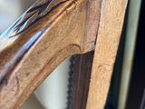 a close up of a wooden chair with a mirror in the background