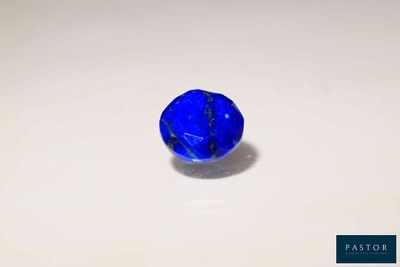 un gros plan d'une bille bleue posée sur une surface blanche