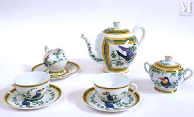 quatre tasses et soucoupes ainsi qu'une théière posées sur une table blanche