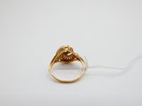 gros plan d'une bague en or sur une surface blanche