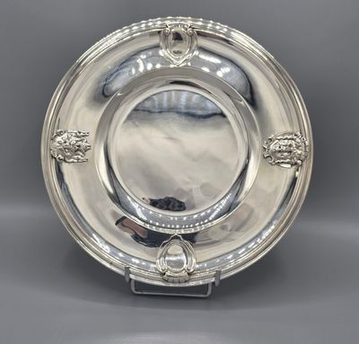 a silver plate with a lion head design on the rim