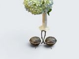 a white vase with blue and green flowers in it