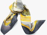 yellow and grey scarf with a design on it on a white surface