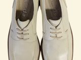 a pair of white shoes that are on a white surface