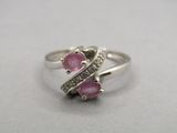 un gros plan d'une bague en argent sertie de pierres roses