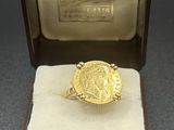 une image représentant une bague en or avec une pièce de monnaie dans une boîte