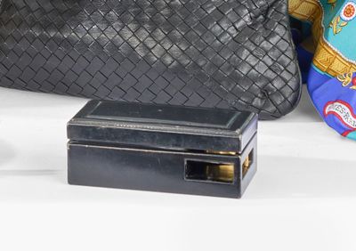 un sac à main noir et un sac à main noir posés sur une table blanche