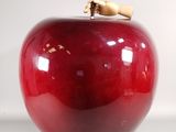 a red apple with a cork on top of it